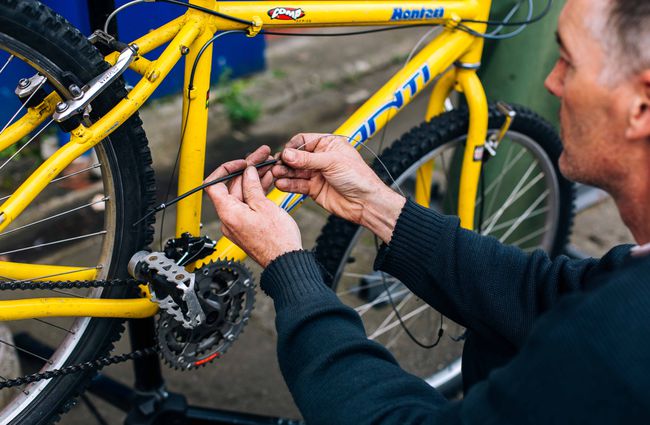 Close up of a man working on a bike.