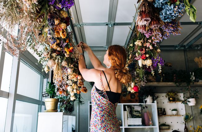 Woman hangs dried flowers.