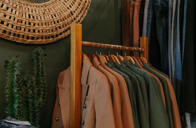A close up of tan coats on a rack sitting next to fake cactus plants at The Red Little Fox store in Fairlie.