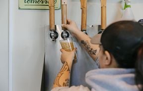 Woman pulling a pint using large wooden handles.