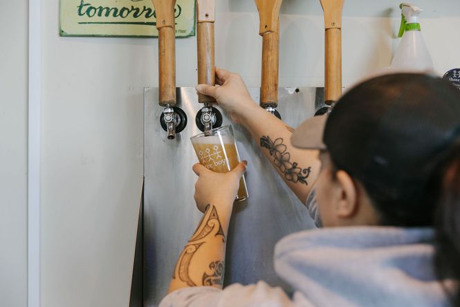 Woman pulling a pint using large wooden handles.