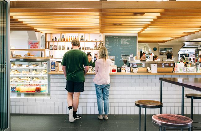Customers standing at the cafe counter ordering at Vic Books', Wellington.