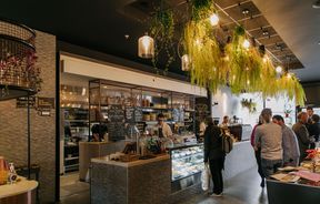 Interior shot showing hanging plants and cafe scene at Westend Stories..