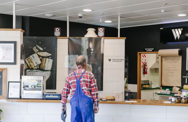 Customer in overalls waiting to be served at Whitestone Cheese Co in Ōamaru.