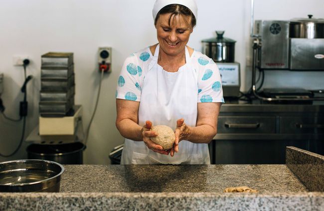 A woman rolling bread dough.