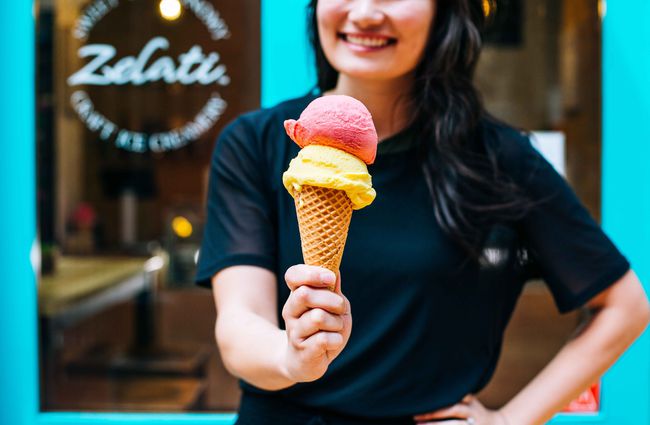 Woman holding ice cream on cone.