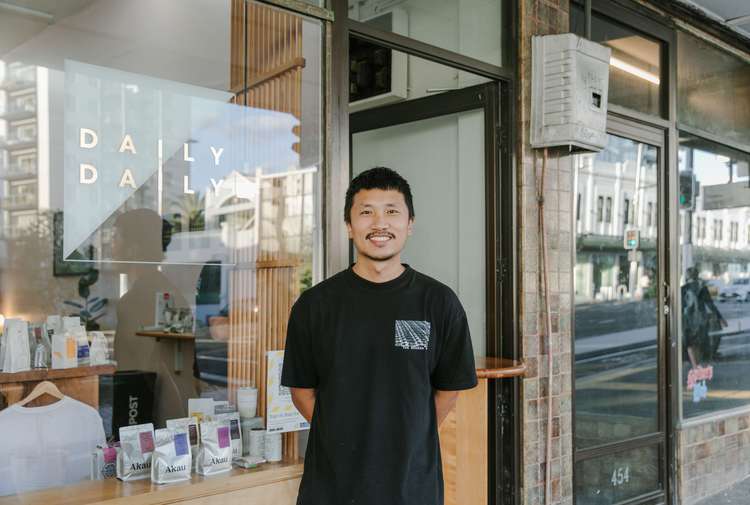 Albert outside his cafe smiling to camera.