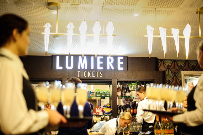 Staff holding drinks and working behind the bar at Lumiere Cinema.