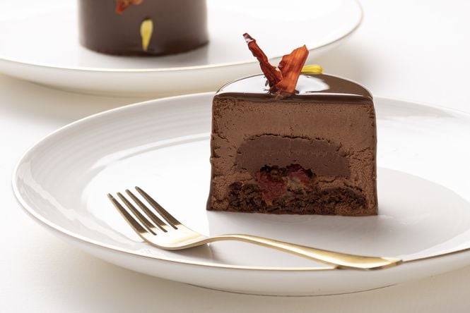 A close up of a round chocolate cake cut open.