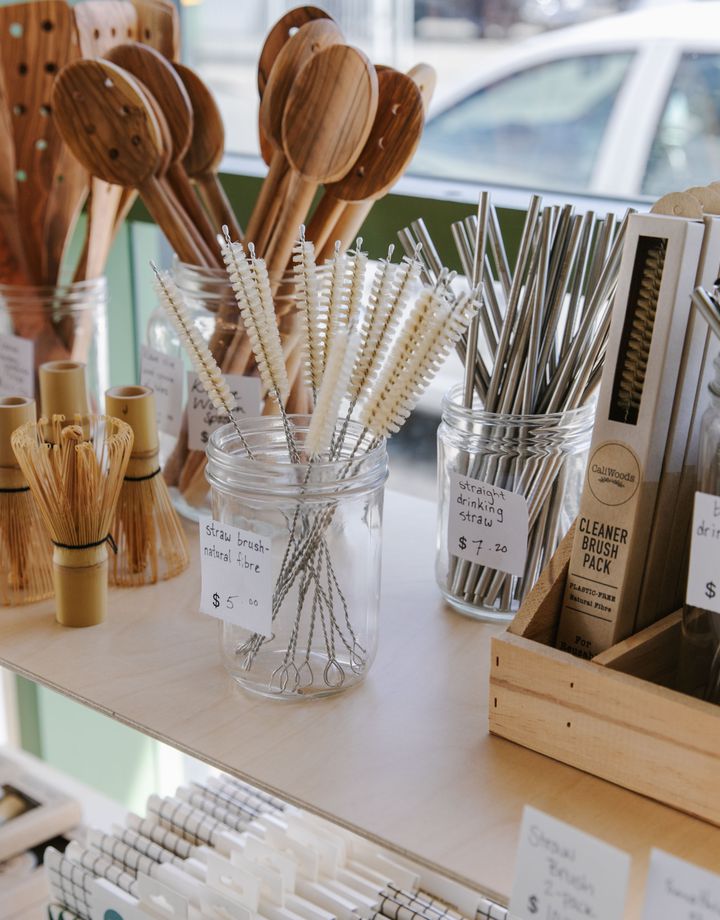A close up of reusable straws and brushes on a shelf inside GoodFor.