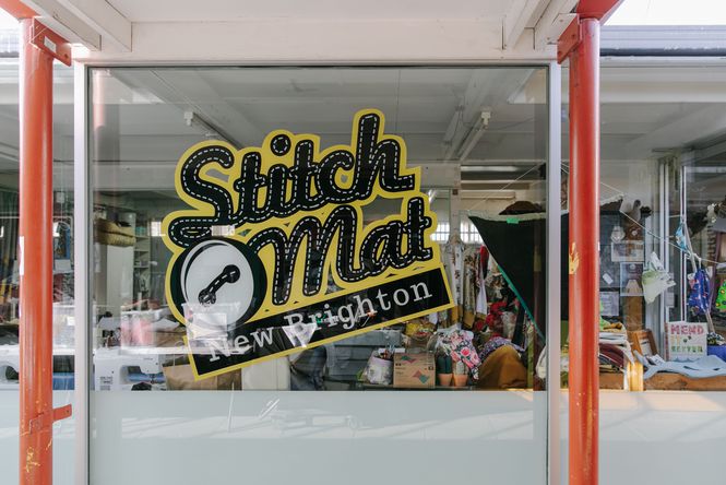 Looking through the window at Stitch Mat with a massive black and yellow logo on the window.