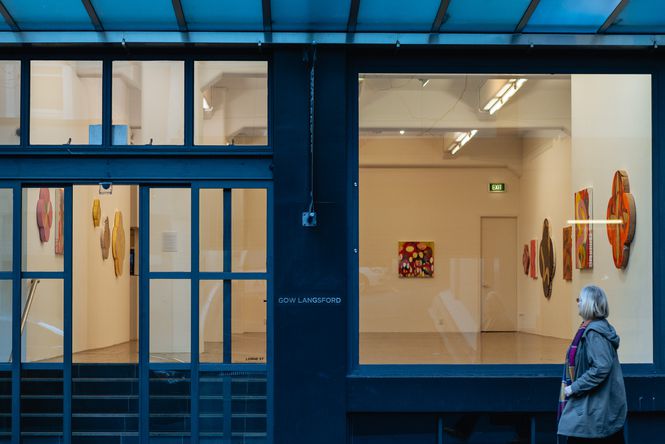 A woman walking past Gow Langsford Gallery.