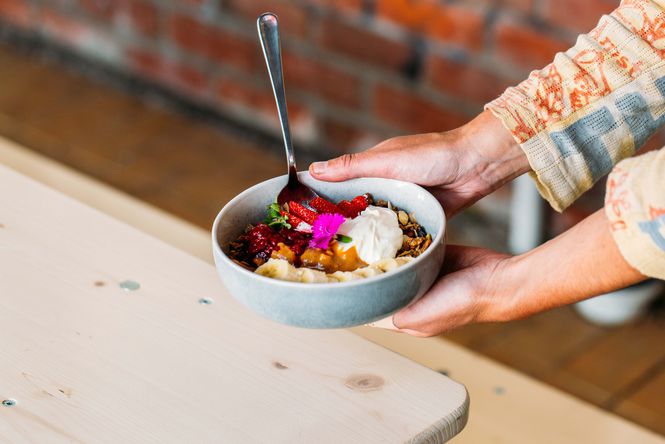 A hand holding a bowl of food.