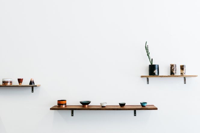 Ceramics lined up on a shelf.